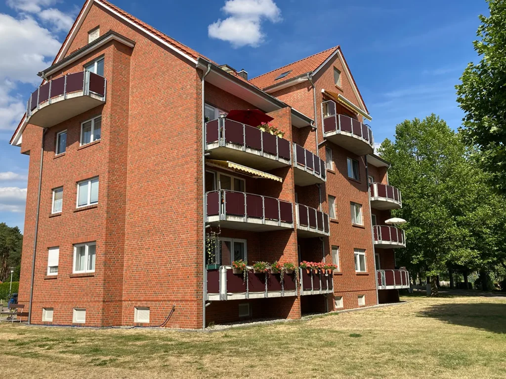 Ansicht des Wohnhauses Eichenweg 1 im Seniorenheim Friedensau mit Wiese und Bäumen